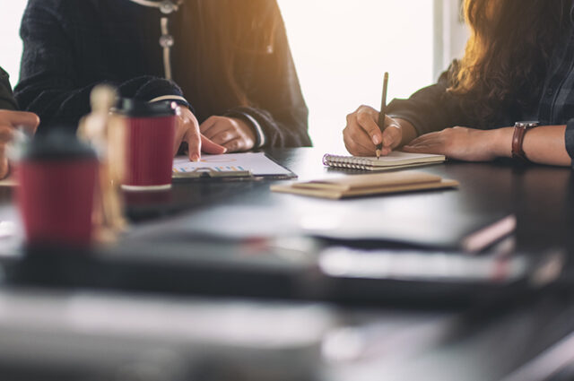 People working at a table during a business meeting