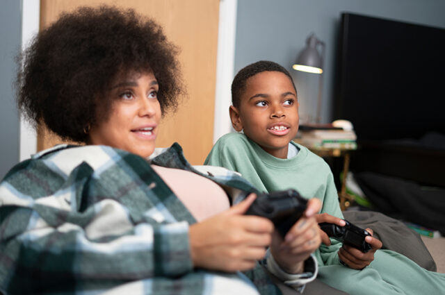 Women and boy playing video game together