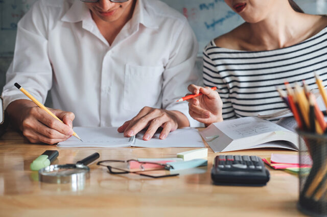 Two people sat working together at a desk