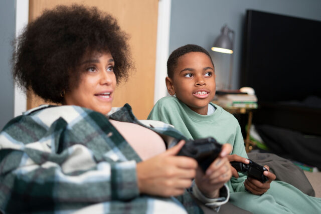 Mother and son playing video games together