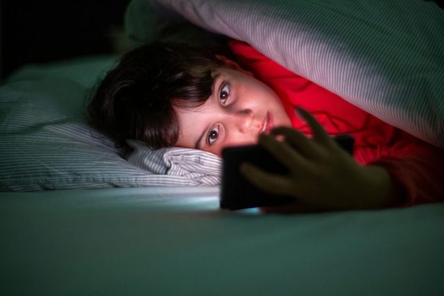 Young person looking at a phone screen
