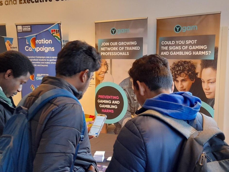 Students looking at a Ygam promotional stall