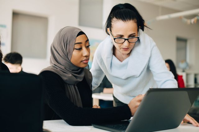 Two women looking at a laptop screen