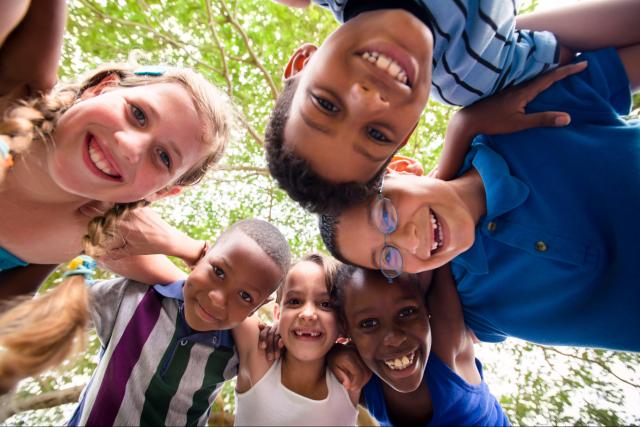 Children in a circle looking down to camera